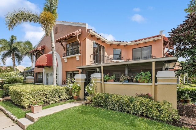 24 Uno Lago Dr, Juno Beach, FL 33408 - view of front of home featuring a balcony, stucco siding, and a tile roof