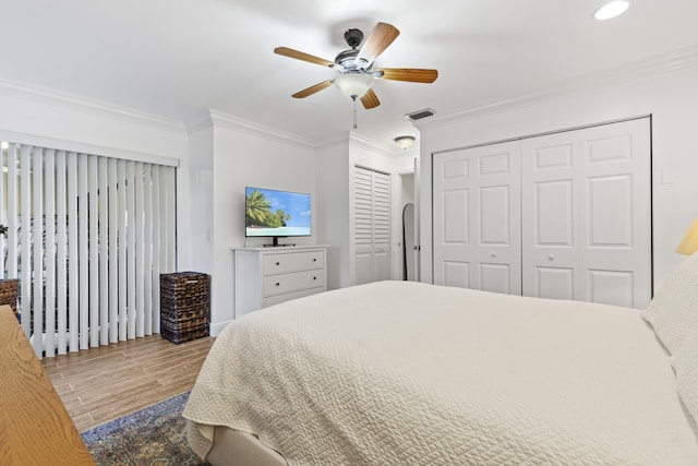23 Lexington Ln W Unit A, Palm Beach Gardens, FL 33418 - bedroom with wood finished floors, crown molding, two closets, recessed lighting, and ceiling fan