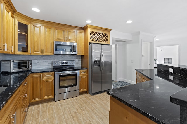 23 Lexington Ln W Unit A, Palm Beach Gardens, FL 33418 - kitchen featuring stainless steel appliances, backsplash, light wood-type flooring, glass insert cabinets, and brown cabinetry