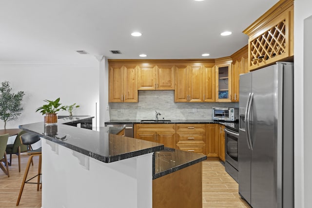 23 Lexington Ln W Unit A, Palm Beach Gardens, FL 33418 - kitchen featuring stainless steel appliances, tasteful backsplash, ornamental molding, light wood finished floors, and glass insert cabinets