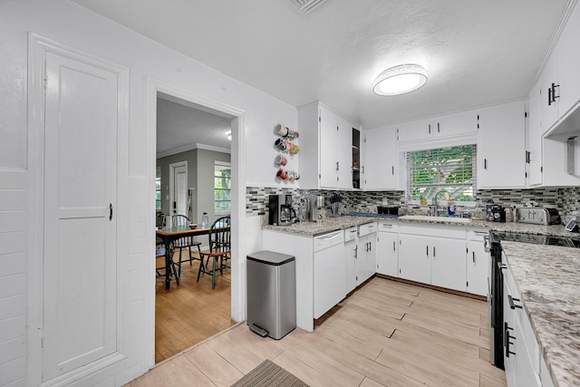 1331 S Palmway, Lake Worth Beach, FL 33460 - kitchen featuring a sink, white dishwasher, stove, backsplash, and white cabinetry