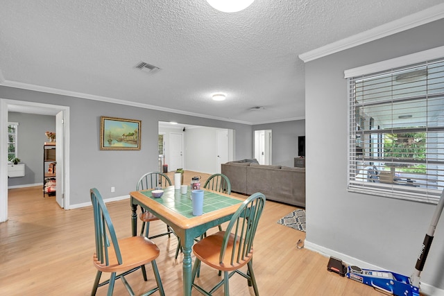 1331 S Palmway, Lake Worth Beach, FL 33460 - dining area with a textured ceiling, wood finished floors, baseboards, crown molding, and healthy amount of natural light