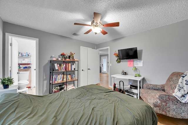 1331 S Palmway, Lake Worth Beach, FL 33460 - bedroom with a textured ceiling, wood finished floors, ensuite bath, and a ceiling fan