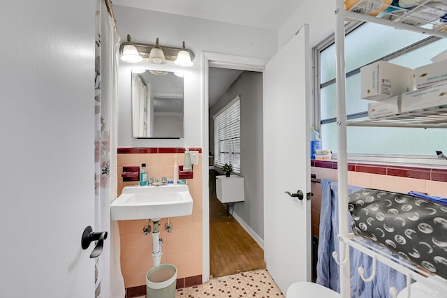 1331 S Palmway, Lake Worth Beach, FL 33460 - half bathroom with tile walls, a wainscoted wall, a sink, and tile patterned flooring