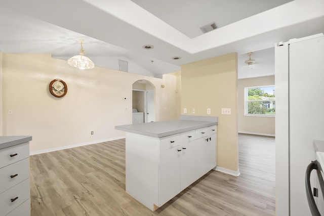 3048 SE Wake Rd, Port Saint Lucie, FL 34984 - kitchen featuring a peninsula, separate washer and dryer, light wood-style flooring, white cabinetry, and light countertops