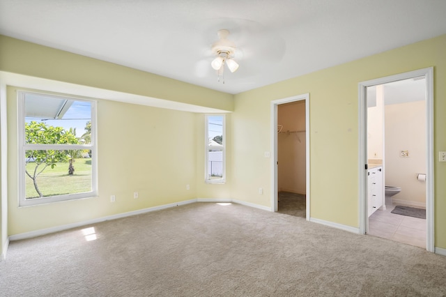 3048 SE Wake Rd, Port Saint Lucie, FL 34984 - unfurnished bedroom featuring light carpet, a spacious closet, baseboards, and ensuite bath