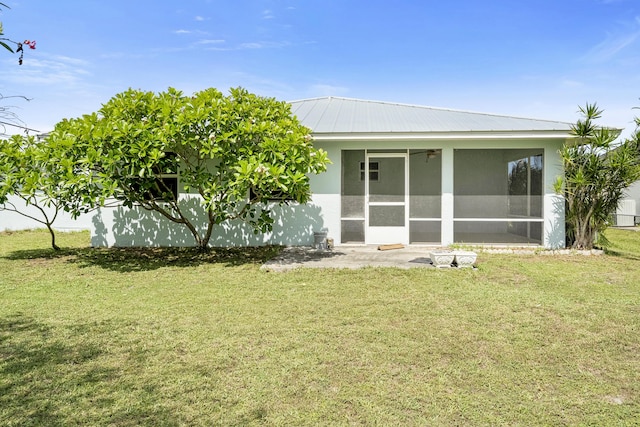 3048 SE Wake Rd, Port Saint Lucie, FL 34984 - back of property with a sunroom, a yard, metal roof, and stucco siding
