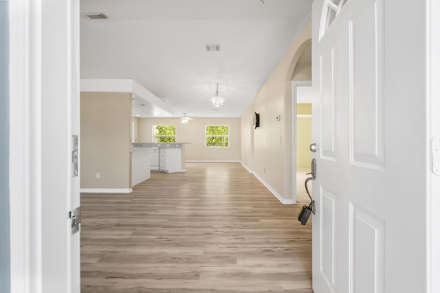 3048 SE Wake Rd, Port Saint Lucie, FL 34984 - entrance foyer with baseboards, light wood-style flooring, arched walkways, and a chandelier