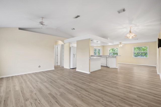 3048 SE Wake Rd, Port Saint Lucie, FL 34984 - unfurnished living room with ceiling fan, arched walkways, baseboards, light wood-type flooring, and lofted ceiling