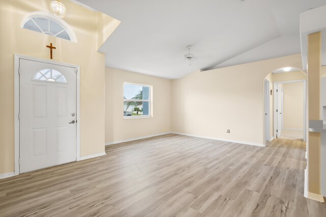 3048 SE Wake Rd, Port Saint Lucie, FL 34984 - foyer entrance featuring arched walkways, light wood-type flooring, vaulted ceiling, and baseboards