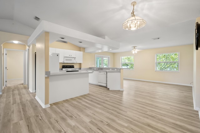 3048 SE Wake Rd, Port Saint Lucie, FL 34984 - kitchen with white appliances, a peninsula, arched walkways, open floor plan, and vaulted ceiling