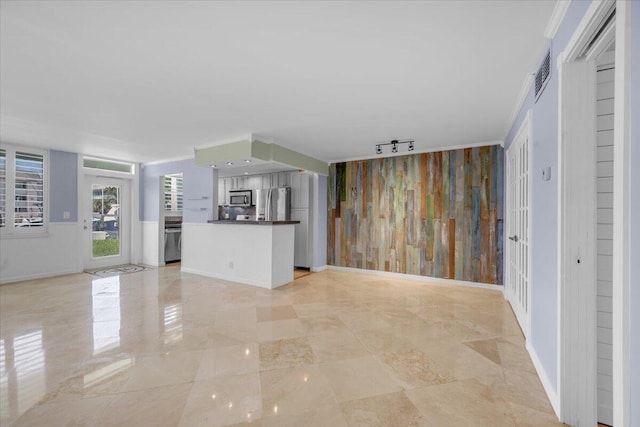 104 Paradise Harbour Blvd Unit 104, North Palm Beach, FL 33408 - unfurnished living room featuring an accent wall and baseboards