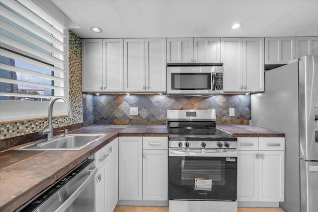 104 Paradise Harbour Blvd Unit 104, North Palm Beach, FL 33408 - kitchen featuring appliances with stainless steel finishes, a sink, decorative backsplash, a textured ceiling, and recessed lighting