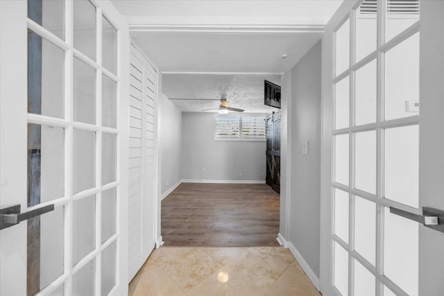 104 Paradise Harbour Blvd Unit 104, North Palm Beach, FL 33408 - hallway with baseboards, light tile patterned floors, and french doors