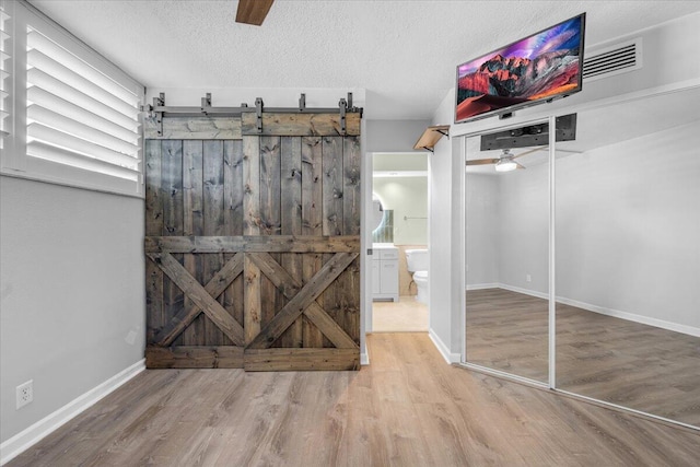 104 Paradise Harbour Blvd Unit 104, North Palm Beach, FL 33408 - unfurnished room featuring ceiling fan, wood finished floors, a textured ceiling, and baseboards