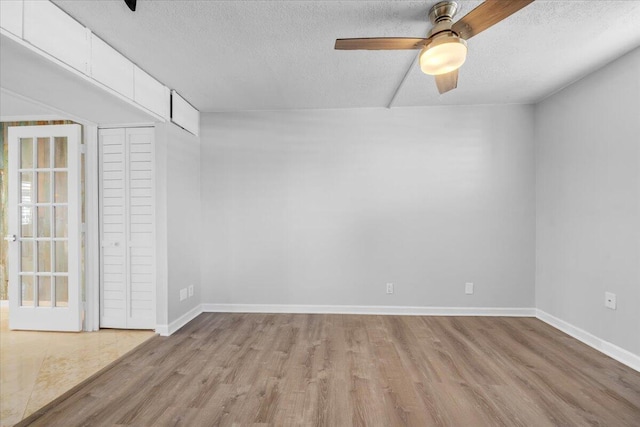 104 Paradise Harbour Blvd Unit 104, North Palm Beach, FL 33408 - unfurnished room with a barn door, a textured ceiling, wood finished floors, baseboards, and ceiling fan