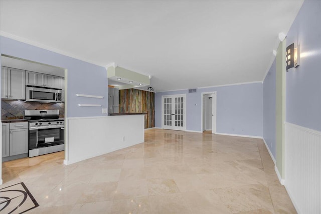 104 Paradise Harbour Blvd Unit 104, North Palm Beach, FL 33408 - unfurnished living room featuring crown molding and wainscoting