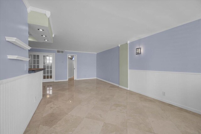 104 Paradise Harbour Blvd Unit 104, North Palm Beach, FL 33408 - empty room featuring wainscoting and crown molding
