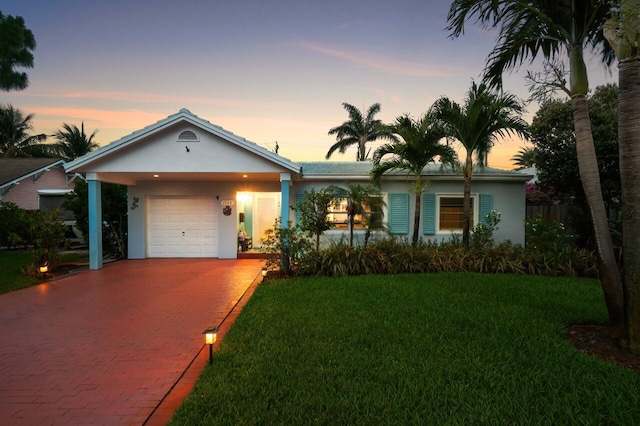1222 N Palmway, Lake Worth Beach, FL 33460 - ranch-style home with stucco siding, decorative driveway, a yard, and an attached garage