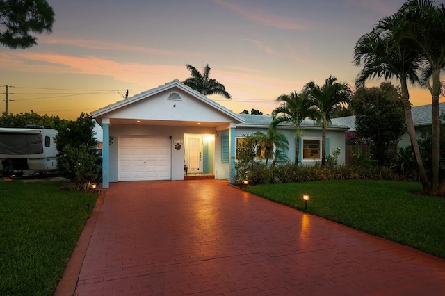 1222 N Palmway, Lake Worth Beach, FL 33460 - ranch-style home featuring stucco siding, decorative driveway, a yard, and an attached garage