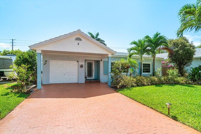 1222 N Palmway, Lake Worth Beach, FL 33460 - ranch-style house with decorative driveway, a front yard, stucco siding, and a garage