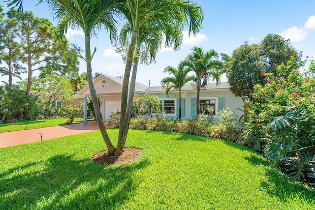1222 N Palmway, Lake Worth Beach, FL 33460 - view of front of home with concrete driveway, a front yard, stucco siding, and an attached garage