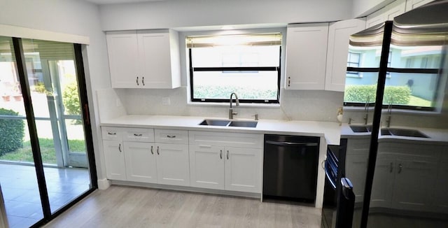 9740 Pecan Tree Dr Unit A, Boynton Beach, FL 33436 - kitchen with dishwashing machine, a sink, light countertops, white cabinetry, and light wood-style flooring