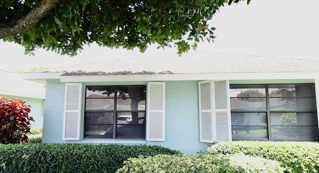 9740 Pecan Tree Dr Unit A, Boynton Beach, FL 33436 - view of exterior entry with stucco siding and roof with shingles