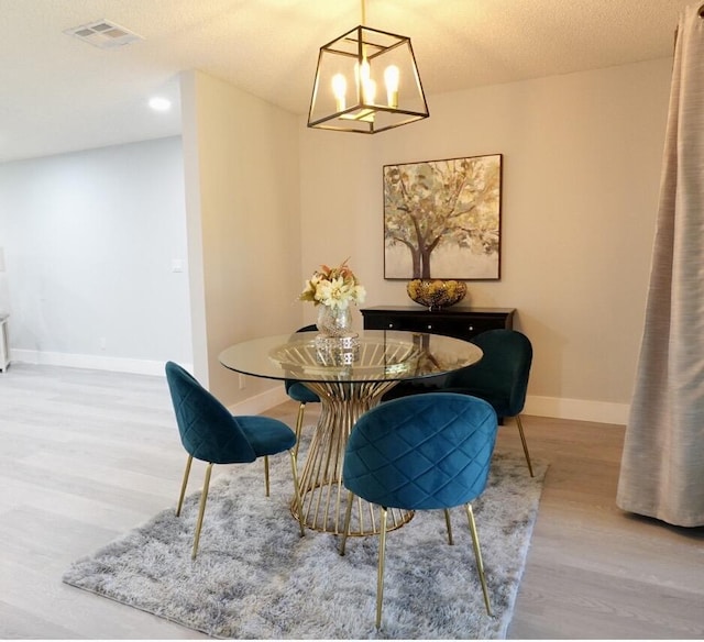 9740 Pecan Tree Dr Unit A, Boynton Beach, FL 33436 - dining space with a chandelier, wood finished floors, baseboards, and a textured ceiling