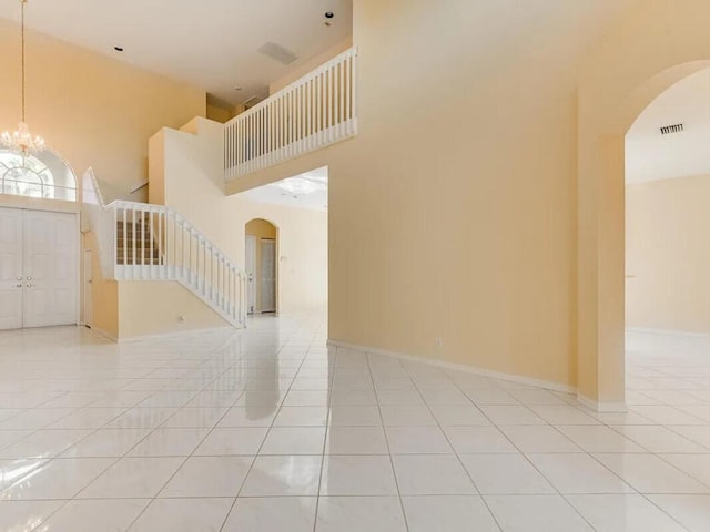 11353 Sea Grass Cir, Boca Raton, FL 33498 - tiled foyer entrance featuring a towering ceiling, arched walkways, a chandelier, and stairs