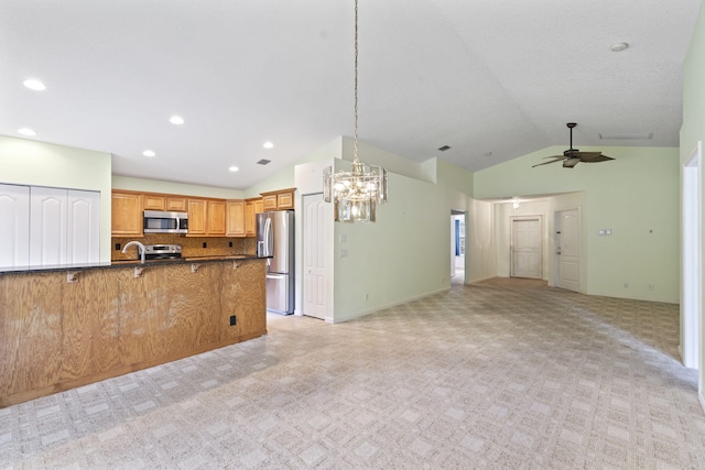 2683 SW Marquis Ter, Stuart, FL 34997 - kitchen featuring appliances with stainless steel finishes, lofted ceiling, open floor plan, dark countertops, and a chandelier