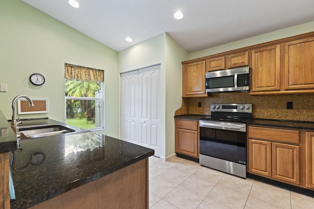 2683 SW Marquis Ter, Stuart, FL 34997 - kitchen featuring stainless steel appliances, tasteful backsplash, brown cabinets, vaulted ceiling, and light tile patterned floors