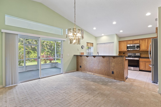 2683 SW Marquis Ter, Stuart, FL 34997 - kitchen featuring stainless steel appliances, a peninsula, light carpet, a chandelier, and backsplash