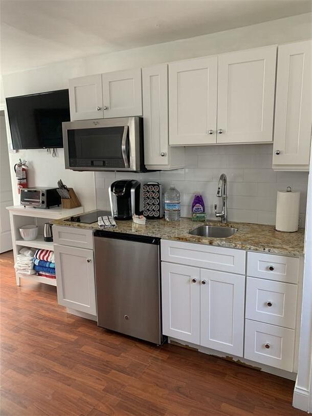 723 N Federal Hwy, Lake Worth Beach, FL 33460 - kitchen featuring stainless steel appliances, a sink, white cabinetry, decorative backsplash, and dark wood-style flooring