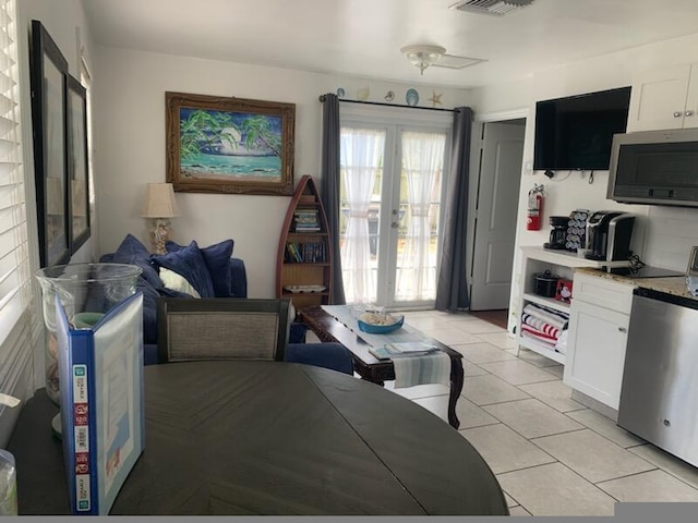 723 N Federal Hwy, Lake Worth Beach, FL 33460 - kitchen with french doors, stainless steel microwave, fridge, light countertops, and white cabinetry