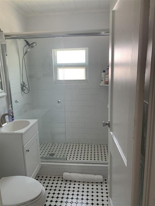 723 N Federal Hwy, Lake Worth Beach, FL 33460 - bathroom with vanity, tile patterned flooring, a shower stall, and toilet