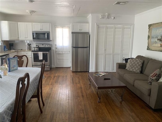723 N Federal Hwy, Lake Worth Beach, FL 33460 - kitchen with stainless steel appliances, light countertops, white cabinetry, crown molding, and dark wood-type flooring