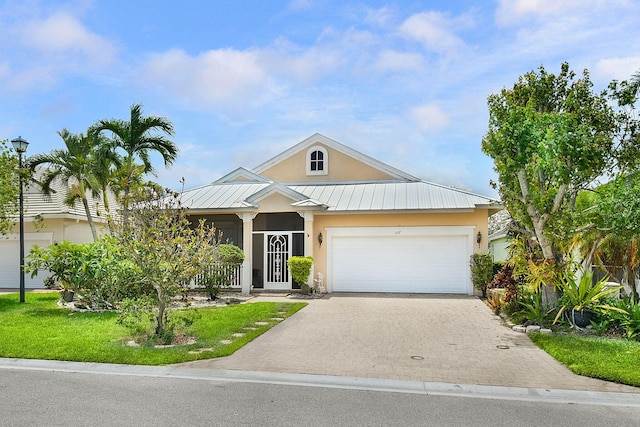107 NW Summerville Ct, Port Saint Lucie, FL 34986 - view of front of home featuring stucco siding, a standing seam roof, driveway, an attached garage, and a metal roof