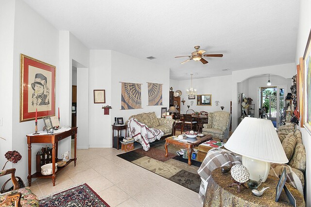 107 NW Summerville Ct, Port Saint Lucie, FL 34986 - living area with a chandelier, a ceiling fan, arched walkways, light tile patterned flooring, and a textured ceiling