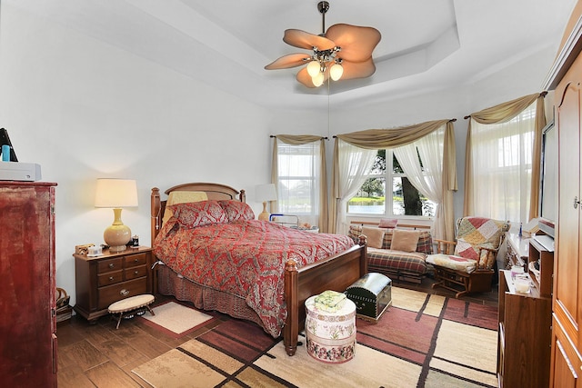 107 NW Summerville Ct, Port Saint Lucie, FL 34986 - bedroom featuring wood finished floors, a ceiling fan, and a raised ceiling