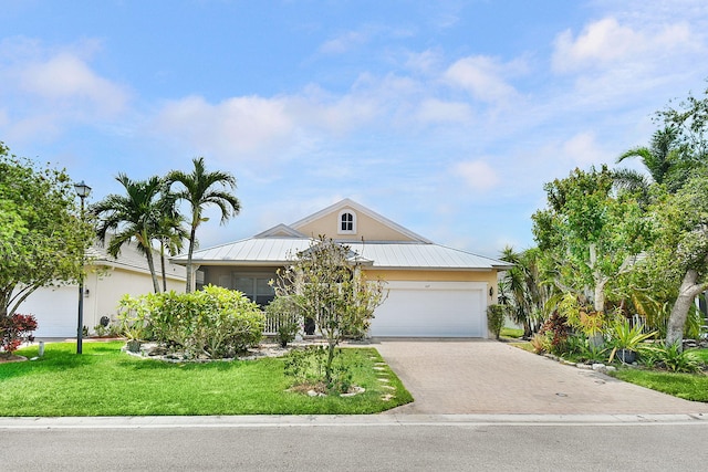 107 NW Summerville Ct, Port Saint Lucie, FL 34986 - view of property hidden behind natural elements with driveway, stucco siding, a front lawn, an attached garage, and a metal roof