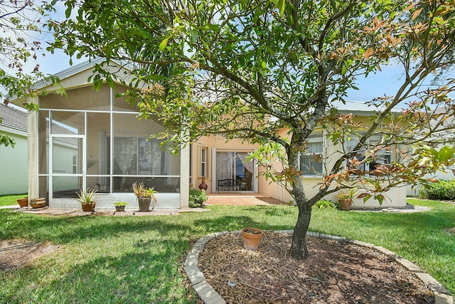 107 NW Summerville Ct, Port Saint Lucie, FL 34986 - back of house featuring a lawn, a sunroom, and stucco siding
