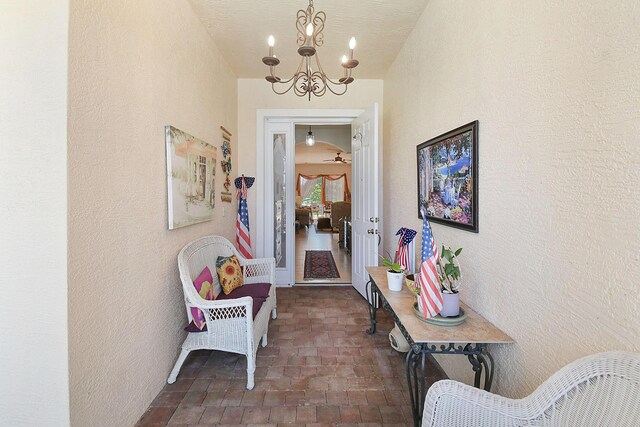 107 NW Summerville Ct, Port Saint Lucie, FL 34986 - hallway featuring a chandelier, brick patterned floors, and a textured wall