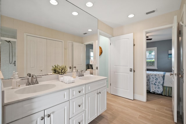 4575 SW Bimini Cir S, Palm City, FL 34990 - full bathroom with ensuite bathroom, double vanity, wood finished floors, wallpapered walls, and recessed lighting
