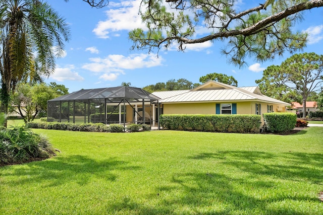 4575 SW Bimini Cir S, Palm City, FL 34990 - back of house with stucco siding, a yard, a standing seam roof, and a lanai