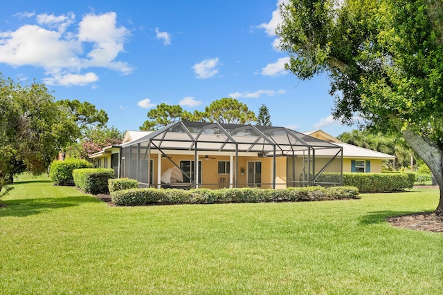 4575 SW Bimini Cir S, Palm City, FL 34990 - back of house with ceiling fan, a yard, and glass enclosure