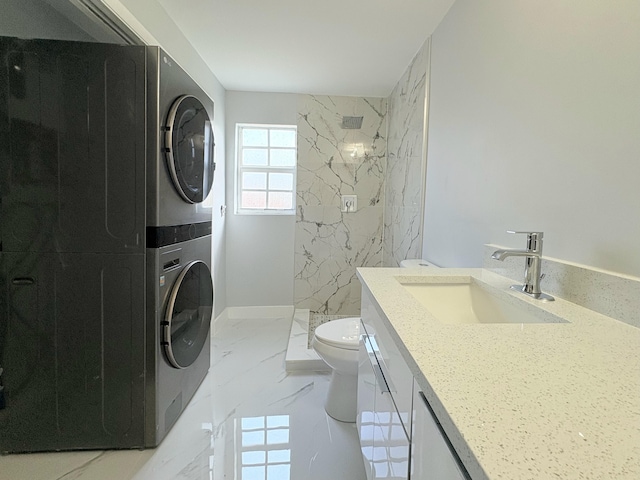 307 4th St, Lake Park, FL 33403 - bathroom featuring estacked washer and dryer, marble tiled floors, toilet, a marble finish shower, and vanity
