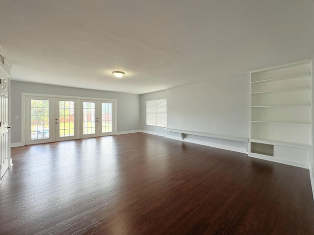 307 4th St, Lake Park, FL 33403 - unfurnished living room with dark wood-style floors, baseboards, and built in features