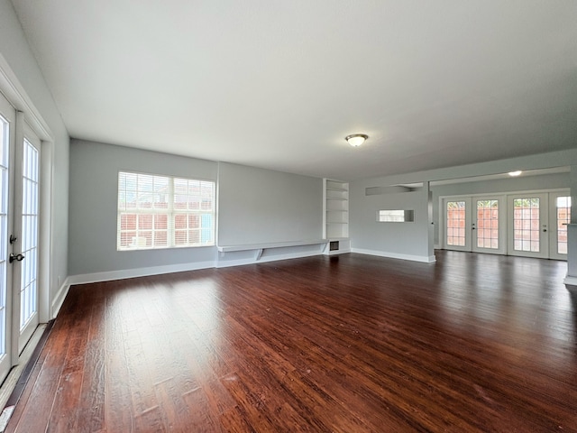 307 4th St, Lake Park, FL 33403 - unfurnished living room featuring dark wood-style floors, baseboards, built in features, and french doors
