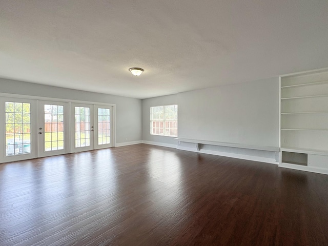 307 4th St, Lake Park, FL 33403 - empty room with dark wood-type flooring, built in shelves, and baseboards